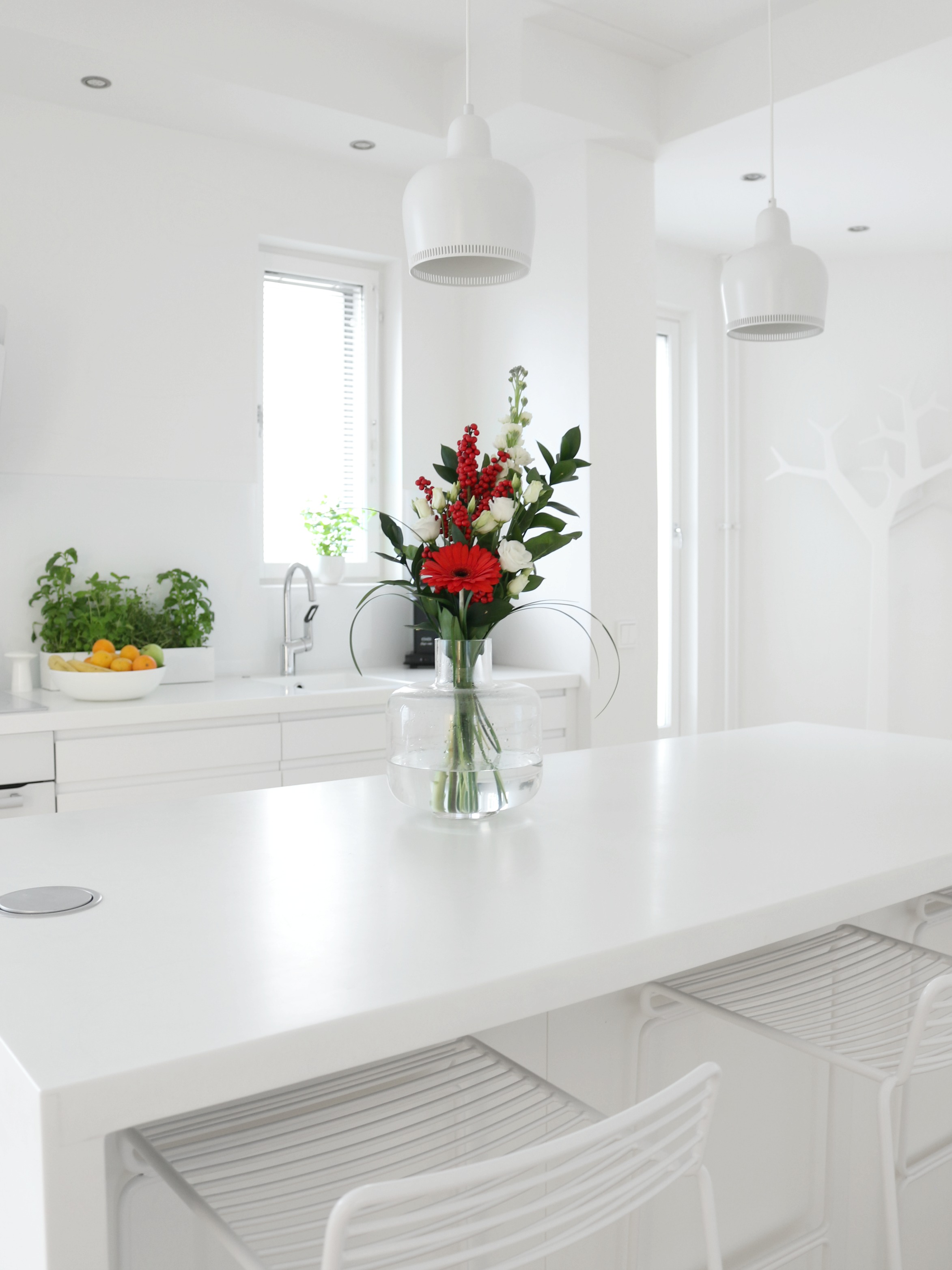 Valkoinen keittiö minimalistinen sisustus keittiövälineet kukkakimppu Omakotivalkoinen
