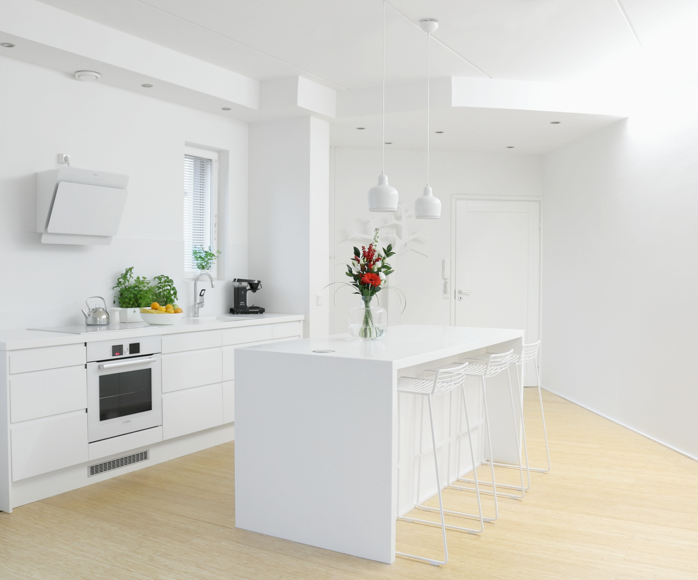 Valkoinen keittiö minimalistinen sisustus keittiövälineet kukkakimppu Omakotivalkoinen